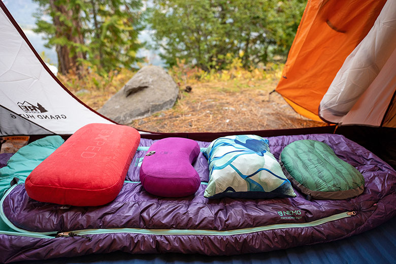 Camping and backpacking pillows (lined up on sleeping bag)
